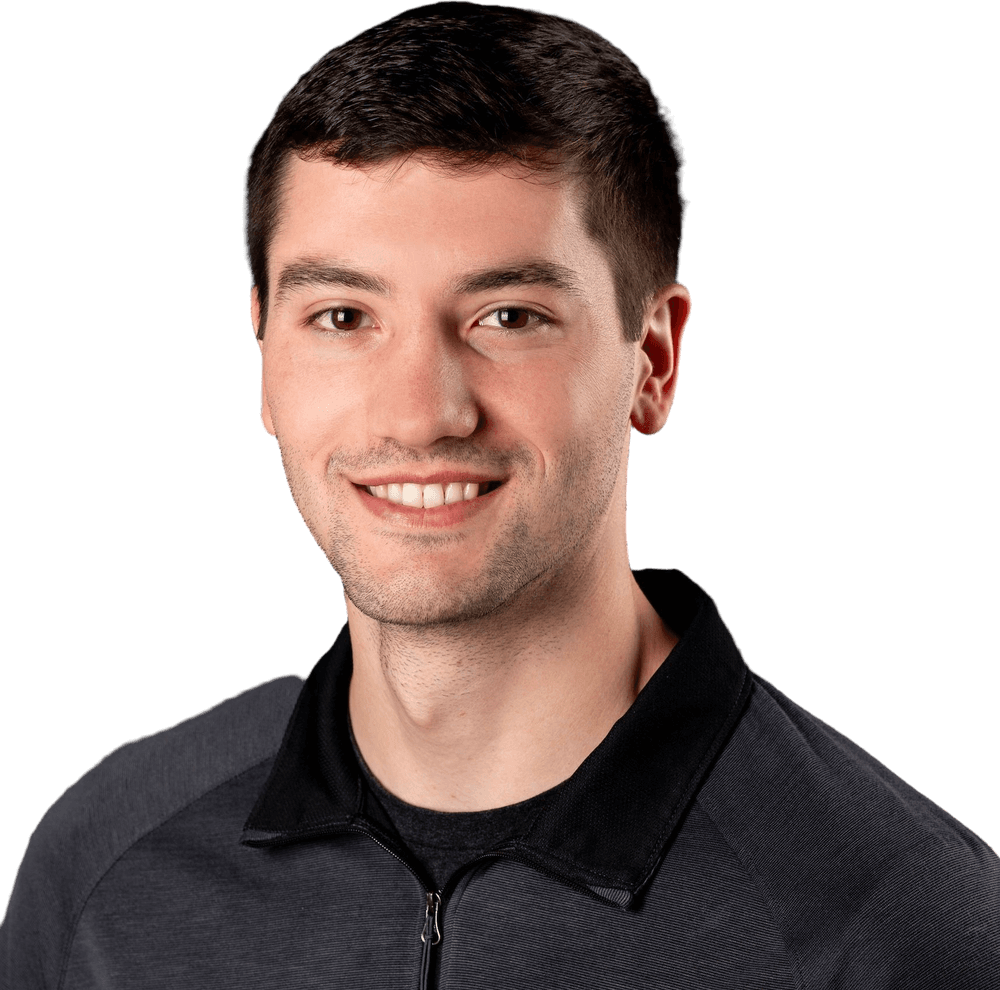 Justin Smith, smiling, in a dark quarter-zip