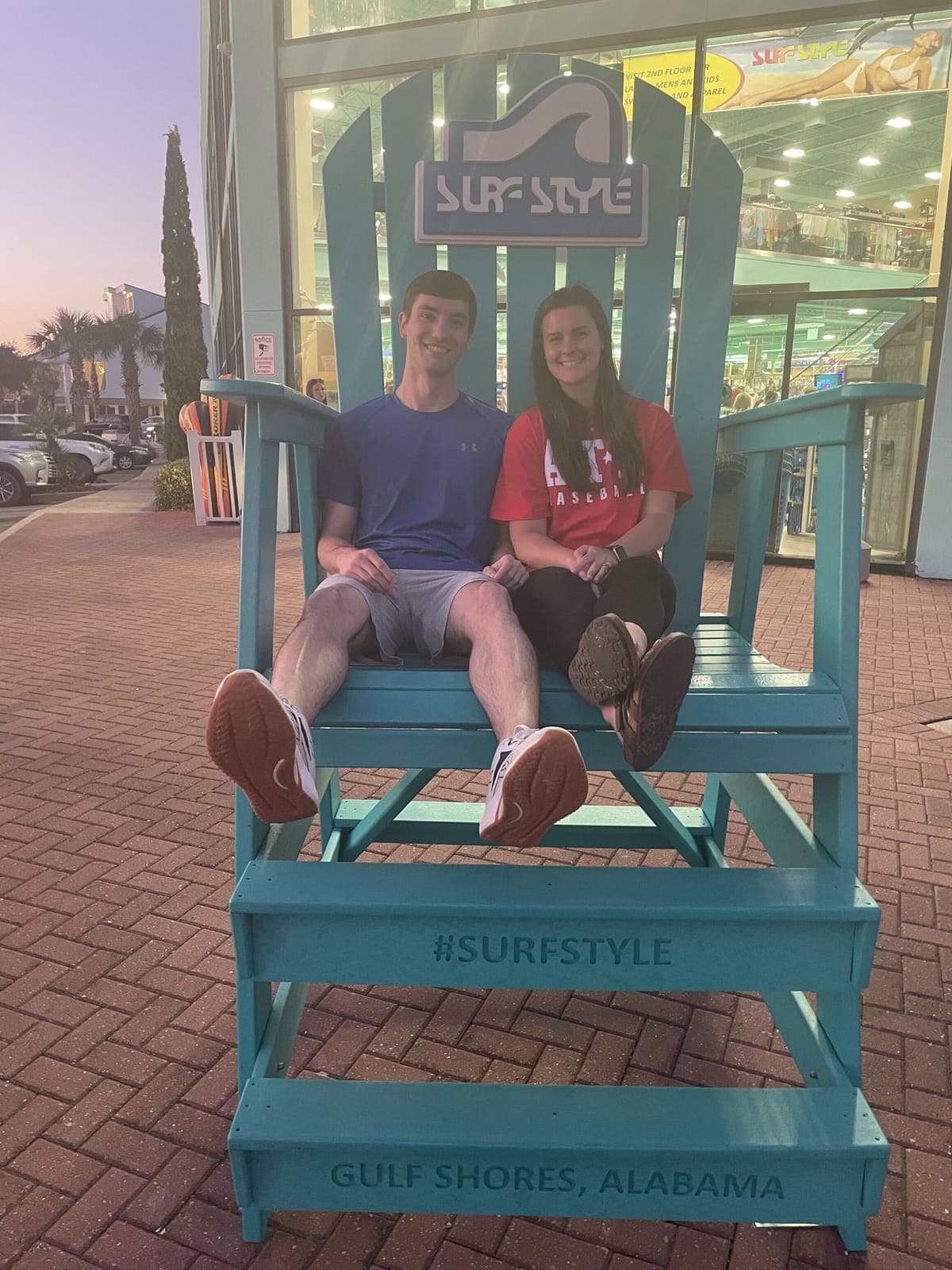Justin and his wife sitting in a giant beach chair in Gulf Shores, Alabama