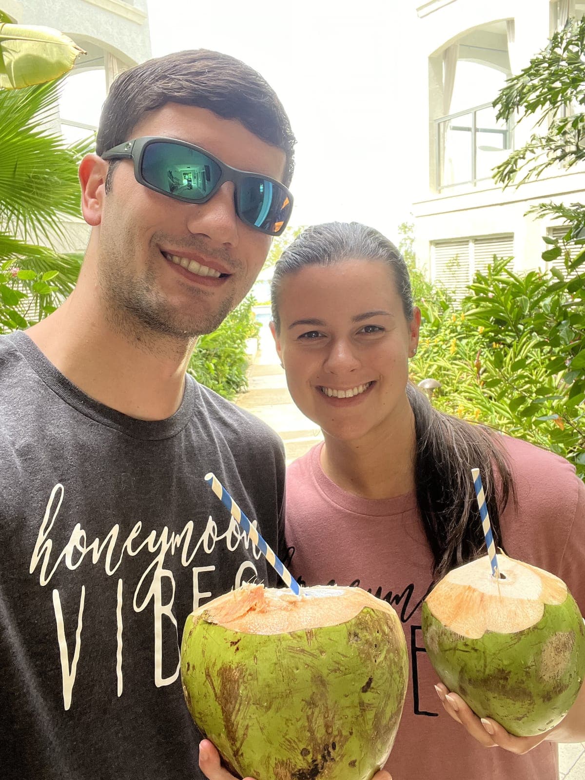 Justin and his wife holding fresh coconuts in Jamaica